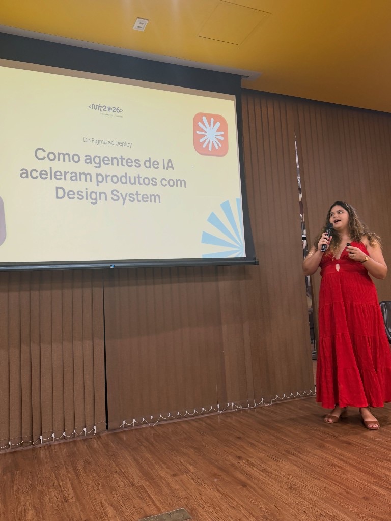 Rebeca Sousa palestrando no MMMT 2026 da Developer Girls, com o slide Do Figma ao Deploy ao fundo.